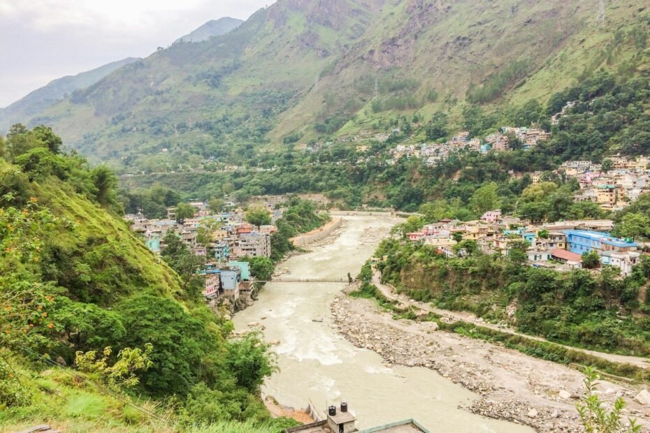 Town nestled in a lush green mountain valley with river