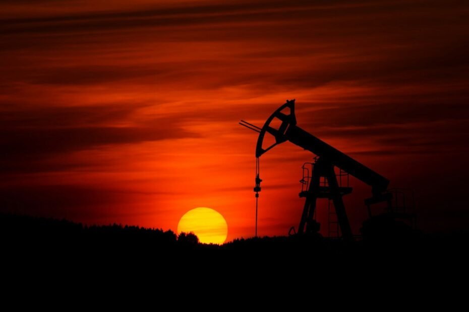 oil pump jack silhouette against red sunset