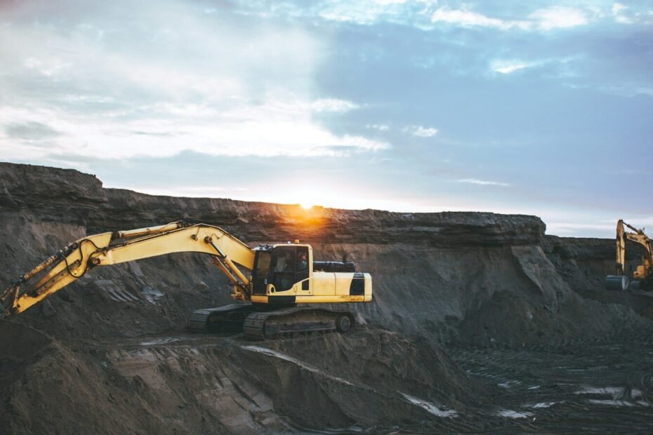 yellow and white excavator on rocky mountain during daytime